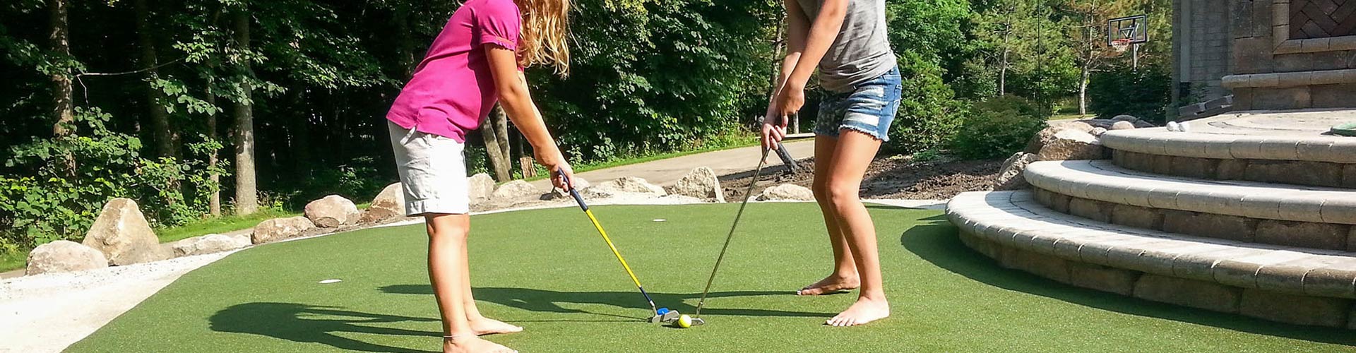 Golfers practicing in backyard putting green