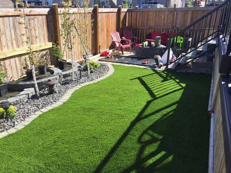Fenced backyard with artificial grass